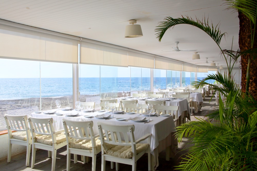 Restaurante del hotel con el mar detrás de la cristalera